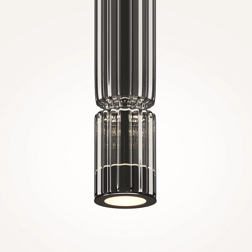 Lampa wisząca LED Ordo H38 o mocy 8W, w kolorze czarnym z dymionym kloszem. Kształt cylindryczny z żłobieniami, zamontowana w pionie. Emituje ciepłe światło, idealna do nowoczesnych wnętrz. Tło jasne, podkreślające detal lampy.