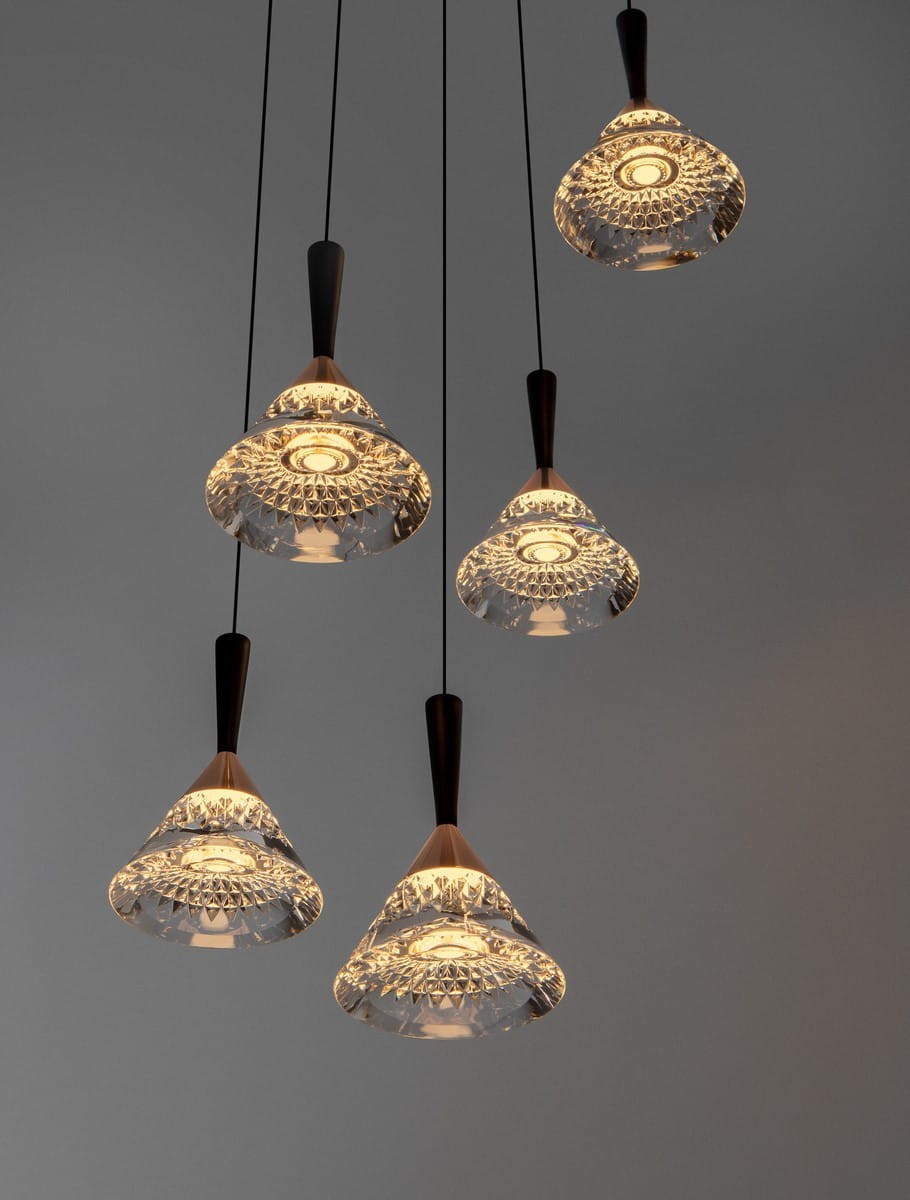 Lampa wisząca Guay 5xLED/30W w kolorze czarnym i złotym, składająca się z pięciu szklanych kloszy o kształcie stożkowatym z ozdobnym wykończeniem. Produkt zawieszony na czarnych przewodach, z widocznym światłem LED wewnątrz kloszy.