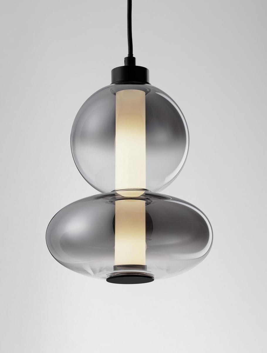 Lampa wisząca Luis z czarnym wykończeniem, złożona z dwóch przezroczystych kloszy w kształcie kul, z centralnym białym źródłem światła LED. Produkt zawieszony na czarnym przewodzie, w minimalistycznym stylu.