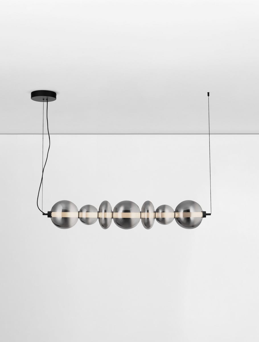 Czarna lampa wisząca Luis z jednym źródłem LED o mocy 40W, zawieszona na cienkim przewodzie. Składa się z ośmiu półkulistych elementów w metalicznym wykończeniu, tworzących nowoczesny design. Ujęcie frontalne, na białym tle.