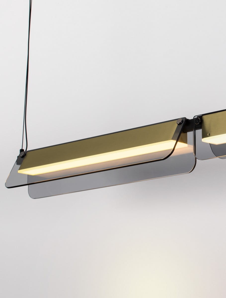 Lampa wisząca Roca z dwoma źródłami LED o mocy 20W w kolorze czarnym i złotym. Zawieszona pod kątem, z prostokątną, transparentną kloszem i eleganckim wykończeniem. Idealna do nowoczesnych wnętrz.