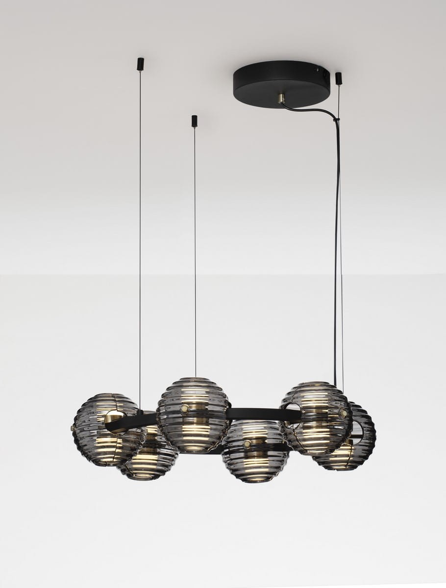 Czarna lampa wisząca Seco z sześcioma kulistymi kloszami w przezroczystym, żłobkowanym szkle. Produkt zawieszony na cienkich linkach, z okrągłym mocowaniem sufitowym. Wymiary i detale wykonania nie są widoczne.