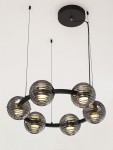 Lampa wisząca Seco z sześcioma kulistymi kloszami w kolorze szarym, wykonana z przezroczystego szkła, na czarnej metalowej ramie. Klosze mają żarówki LED o mocy 60W, zawieszona na cienkich linkach.