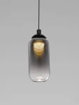 Lampa wisząca Toay w kolorze czarnym z kloszem ze szkła w kształcie cylindrycznym, zawieszona na czarnym przewodzie. Źródło światła LED 1x6W, z widocznym ciepłym światłem w dolnej części klosza. Tło szare, proste.