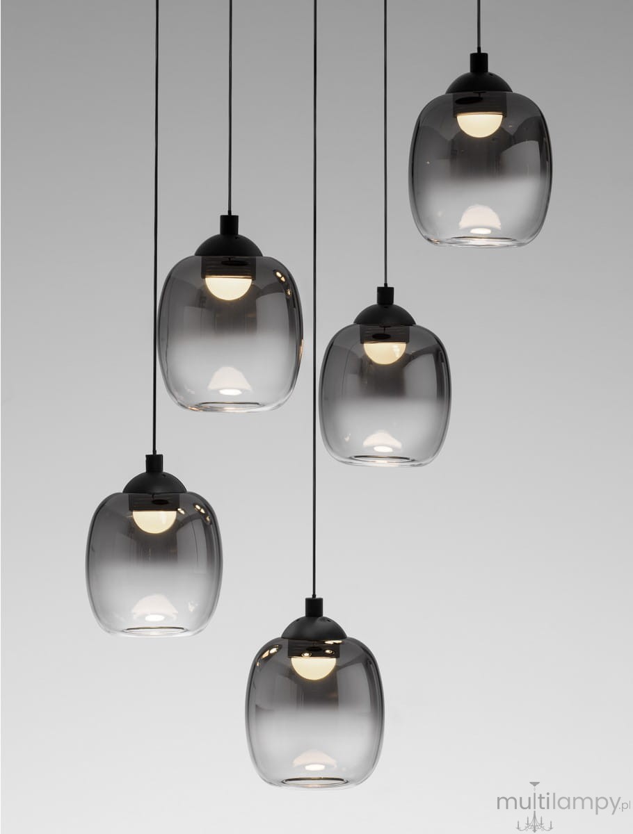 Lampa wisząca Toay z pięcioma kloszami LED o mocy 28W, w kolorze czarnym. Klosze mają transparentny, lekko przyciemniony wygląd, zawieszone na czarnych linkach, emitując ciepłe światło. Ujęcie frontalne.