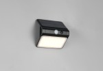 Kinkiet zewnętrzny Olinda w kolorze czarnym, zintegrowany panel solarny i czujnik ruchu. Wbudowana lampa LED 1x2,5W. Produkt zamontowany na ścianie, z widoczną jasną powierzchnią emitującą światło i czujnikiem na przedniej ściance.