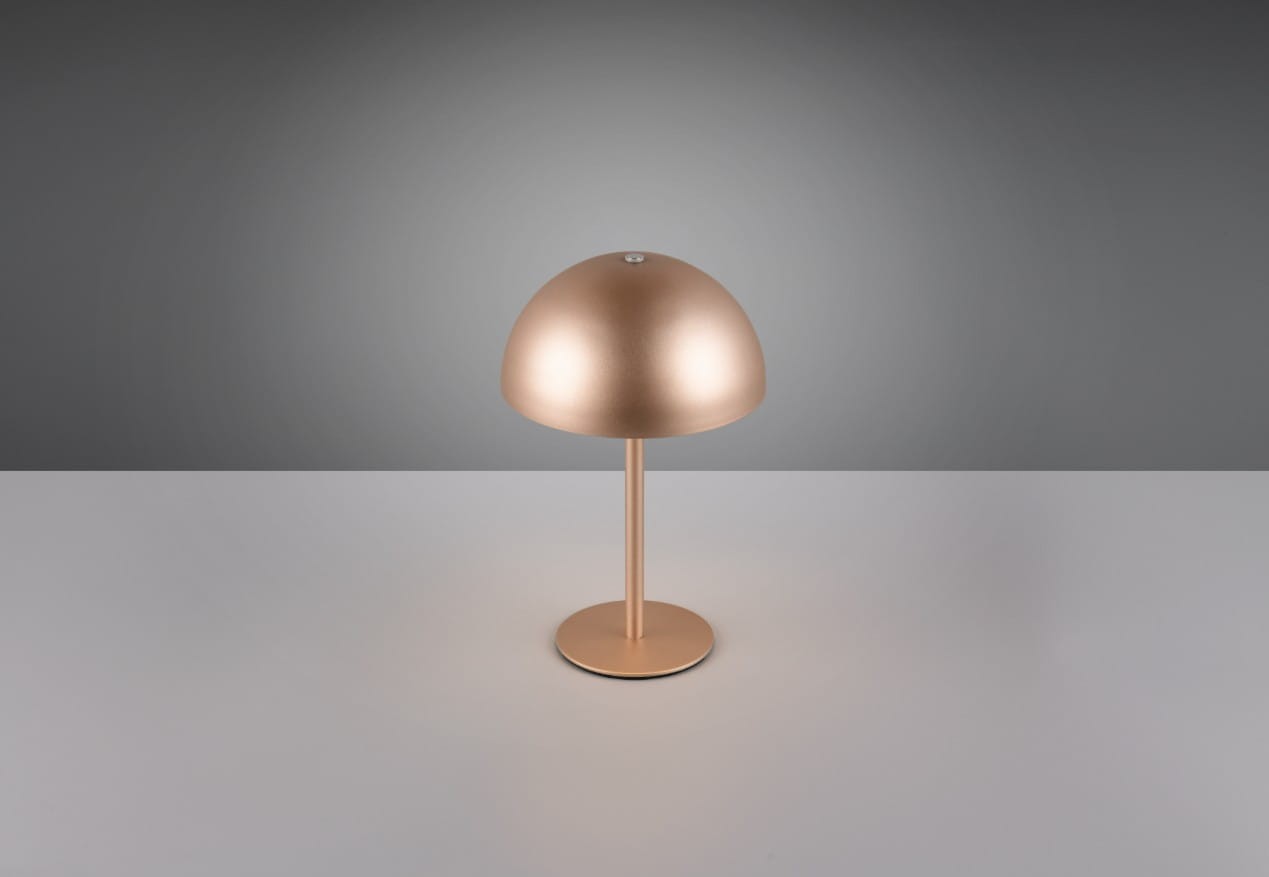 Lampa stołowa Munoz w kolorze kawowym, z metalową podstawą i zaokrąglonym kloszem. Stoi na płaskiej powierzchni, prezentując nowoczesny design. Wbudowane źródło LED o mocy 1,3W, idealna do minimalistycznych aranżacji.