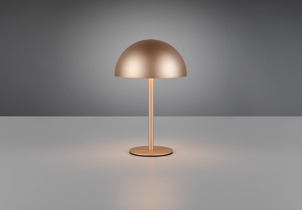 Lampa stołowa Munoz w kolorze kawowym z metalowym kloszem w kształcie półkuli. Posiada prostą, okrągłą podstawę i smukły, prosty trzonek. Ujęcie frontalne, na jednolitym tle, z widocznym źródłem światła LED o mocy 1,3W.