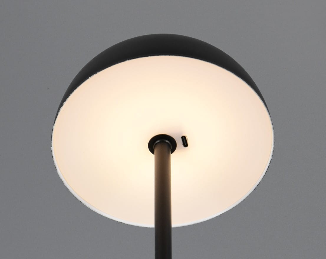 Czarna lampa stołowa Munoz z jednym źródłem światła LED (1,3W). Ujęcie z dołu, pokazujące okrągły klosz z białym wnętrzem oraz smukły czarny trzon. Widoczny element do włączania/wyłączania.