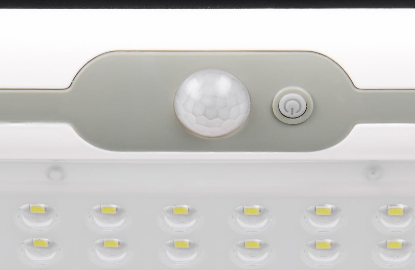 Kinkiet zewnętrzny solarno-LED w kolorze białym, z czujnikiem ruchu i zmierzchu. Widoczny czujnik w kształcie kuli oraz przycisk włączania. Posiada 12 diod LED rozmieszczonych w dwóch rzędach. Zamontowany na górze, z prostym, nowoczesnym designem.