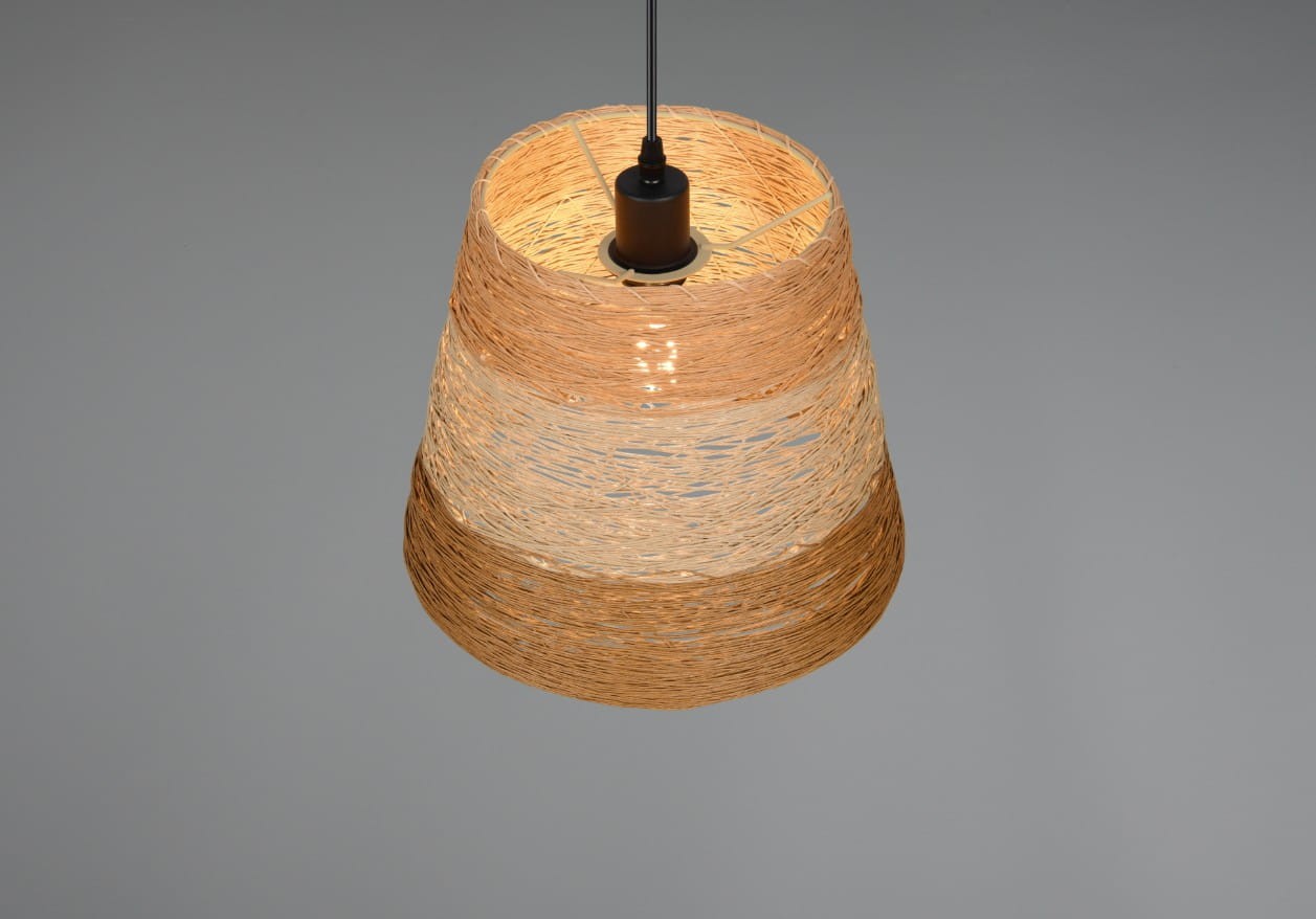 Lampa wisząca Joeline z kloszem w kolorze brązowym i czarnym, o okrągłym kształcie. Klosz wykonany z plecionki, wisi na cienkim, czarnym przewodzie. Widoczne źródło światła E27 w górnej części. Tło jasnoszare, co podkreśla design lampy.