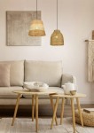 Lampa wisząca Joeline z jedną oprawą E27, o kształcie stożkowym, w kolorze czarnym i brązowym. Zawieszona nad kanapą w jasnym wnętrzu, z naturalnym wykończeniem, z widocznymi elementami dekoracyjnymi w otoczeniu.