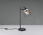 Lampa stołowa Jarome z metalowym korpusem w kolorze czarnym i kloszem z naturalnego materiału. Ujęcie z boku, stojąca na płaskiej powierzchni, z widocznym przewodem z włącznikiem. Idealna do nowoczesnych wnętrz.