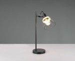 Lampa stołowa Jarome w kolorze czarnym z naturalnym kloszem. Posiada metalowy stelaż z okrągłą podstawą oraz szklany żarówkę osłoniętą siatką. Ujęcie z boku, eksponujące detal klosza i stylowy design. Tło neutralne, szare.
