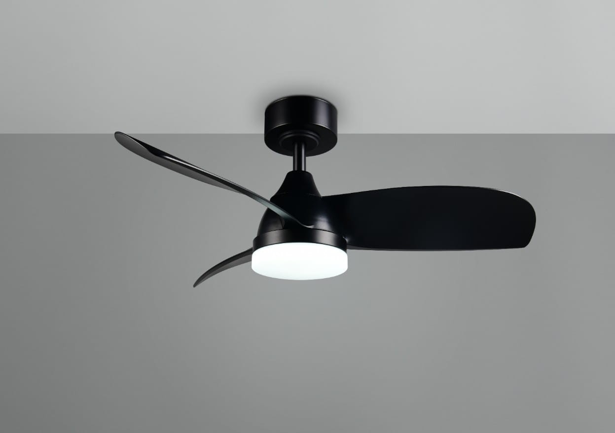 Czarna lampa sufitowa z wentylatorem, wyposażona w okrągłą, białą oprawę LED o mocy 20W. Posiada dwa aerodynamiczne skrzydła i jest zamontowana na suficie. W zestawie pilot do zdalnego sterowania.