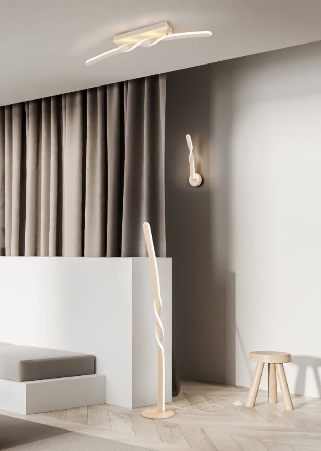 Lampa sufitowa Ginko w kolorze piaskowym, z jedną żarówką LED o mocy 18W. Posiada nowoczesny, zakrzywiony kształt, montowana na suficie. W tle widać zasłony i inne elementy wystroju wnętrza, co podkreśla jej zastosowanie w aranżacji.