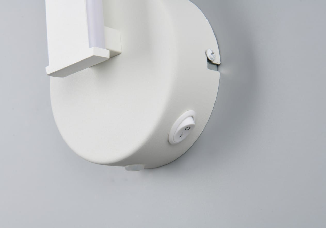Biały kinkiet Ginko z jedną diodą LED o mocy 11W. Widoczny okrągły uchwyt montażowy, przycisk włączania na dole. Prosty, nowoczesny design, idealny do różnych wnętrz.