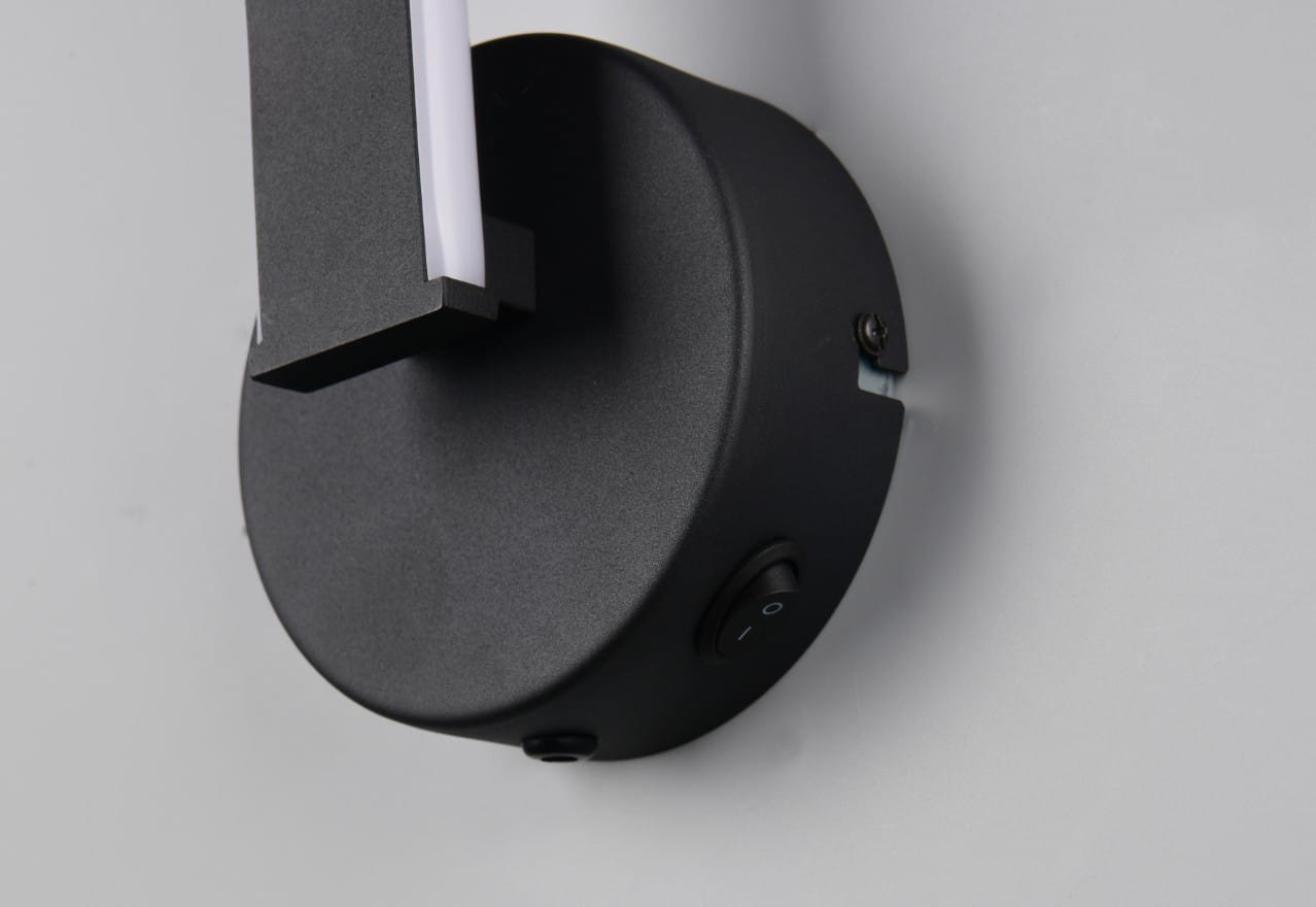 Kinkiet Ginko 1xLED/11W w kolorze czarnym, z okrągłą podstawą i prostokątnym ramieniem. Widoczny przycisk włącznika oraz minimalistyczny design. Ujęcie z boku, na jednolitym tle.