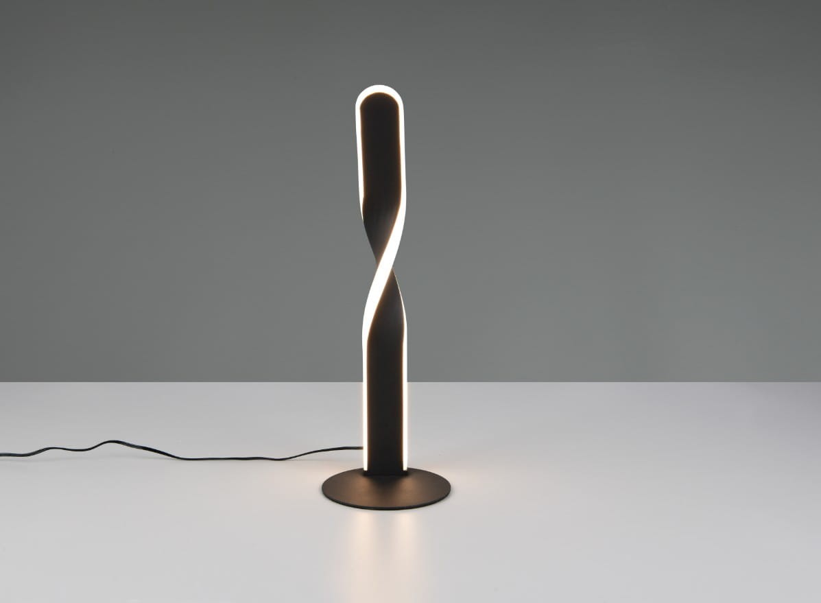 Lampa stołowa Ginko, czarna, z LED o mocy 10W. Ma smukły, spiralny kształt z podświetleniem, stojąca na okrągłej podstawie. W kablu widoczna wtyczka, tło jasne, minimalistyczne. Idealna do nowoczesnych wnętrz.