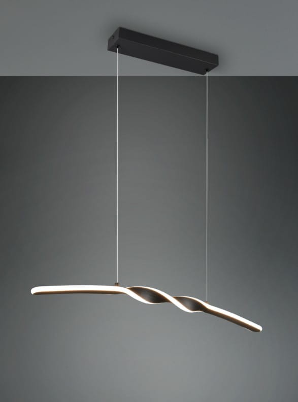Lampa wisząca Ginko w kolorze czarnym, z jedną diodą LED o mocy 18W. Ma smukły, falisty kształt oraz jest zawieszona na przezroczystych linkach. Montowana do sufitu na prostokątnej podstawie. Tło w odcieniach szarości.