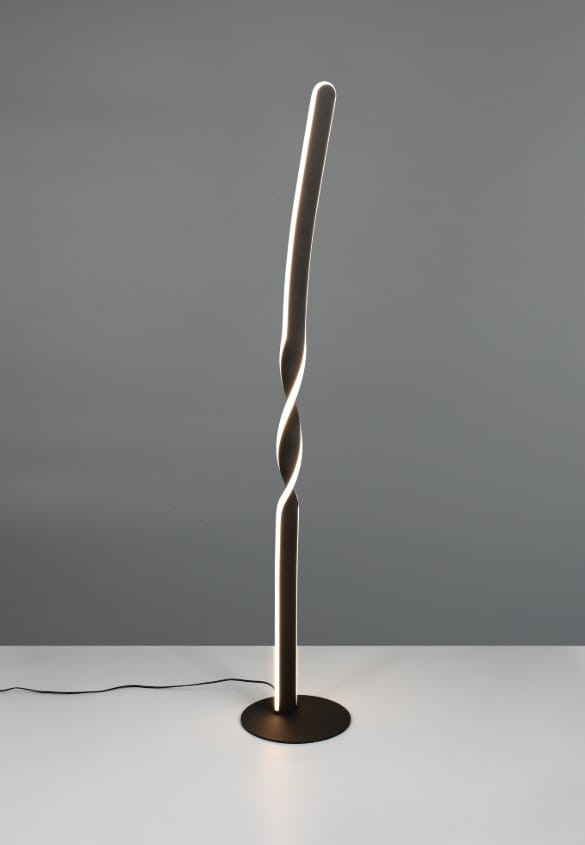 Lampa podłogowa Ginko w kolorze czarnym, wykonana z metalu, o smukłym, spiralnym kształcie. Posiada jedną żarówkę LED o mocy 19W. Stoi na okrągłej podstawie, z widocznym przewodem zasilającym, na szarym tle.