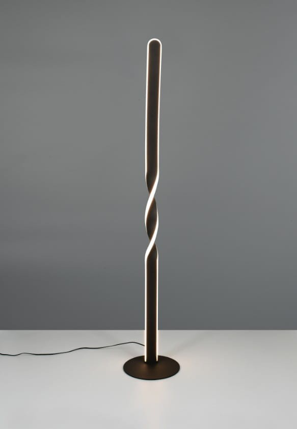 Lampa podłogowa Ginko w kolorze czarnym z jedną żarówką LED o mocy 19W. Posiada smukły, spiralny kształt z podświetleniem. Stoi na okrągłej podstawie, z kablem widocznym na podłodze. Tło w odcieniu szarym.