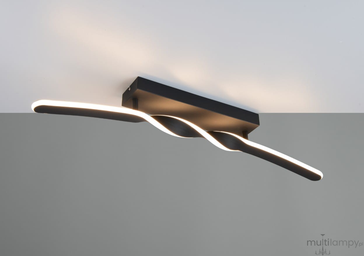 Lampa sufitowa Ginko w kolorze czarnym, z jedną listwą LED o mocy 18W. Kształt falisty, zamontowana na prostokątnej podstawie. Oświetlenie emitowane z boku, na jasnym tle.