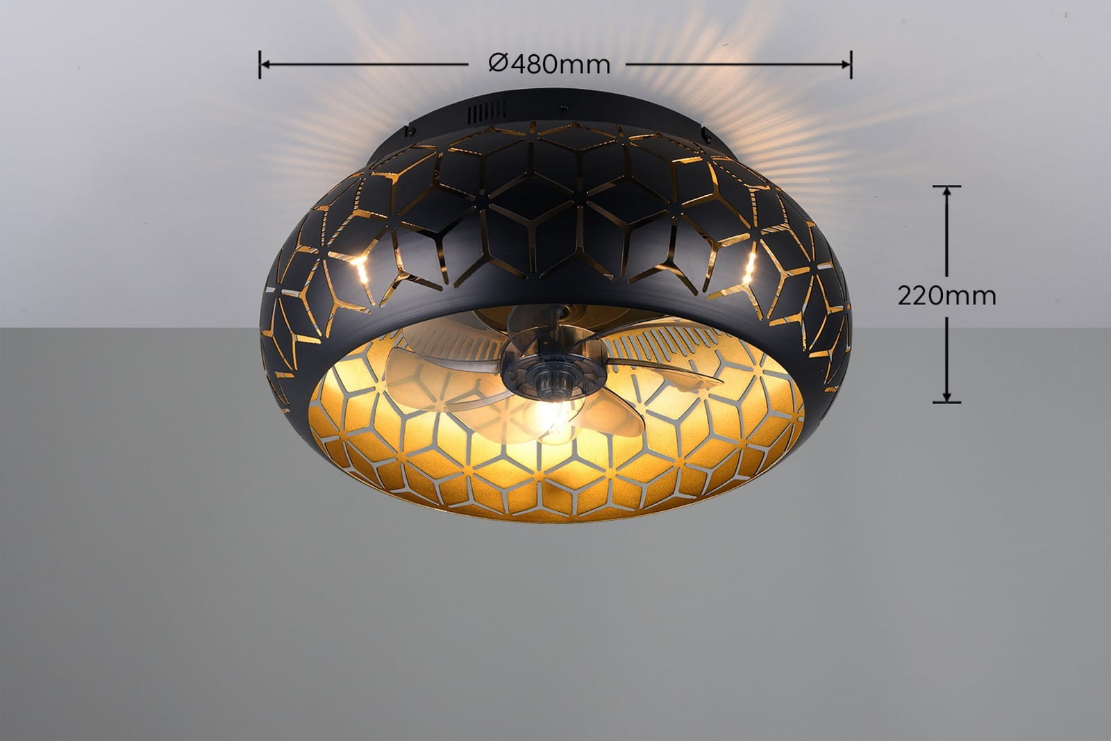 Bidar lampa sufitowa z wentylatorem, czarna, o średnicy 480 mm i wysokości 220 mm. Wnętrze w kolorze złotym z geometrycznym wzorem. Widoczny wentylator oraz miejsce na żarówkę E27. Produkt zamontowany na tle jasnej ściany.