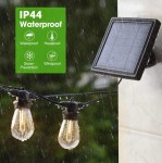 Girlanda solarna 20 m z 20 żarówkami LED E27 1W w kolorze czarnym. Ujęcie z boku, pokazujące podwieszone żarówki w deszczu oraz panel solarny zamontowany na ścianie. Widoczne oznaczenia IP44, wskazujące na odporność na wodę, mróz i wiatr.