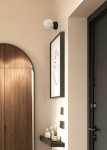 Lampa sufitowa Aura 1xG9 w kolorze czarnym z transparentnym kloszem, montowana na ścianie. Klosz ma okrągły kształt z teksturowaną powierzchnią. Produkt umieszczony w nowoczesnym wnętrzu obok obrazu i dekoracji na półce.