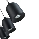 Lampa wisząca Nilo w kolorze czarnym z trzema kloszami, wykonana z matowego metalu. Ujęcie z boku, pokazujące okrągłe podstawy z oprawkami GU10. Klosze mają zaokrąglony kształt, zawieszone na cienkich przewodach.