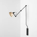 Kinkiet Aida 1xE27 w kolorze czarnym i beżowym, z ruchomą głowicą w kształcie stożka. Montowany na ścianie, z metalowym ramieniem i prostokątną podstawą. Ujęcie z boku, na tle białej ściany.