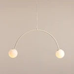 Lampa wisząca Una Cream z dwoma kulistymi kloszami, wykonana w odcieniu kremowym. Kształt łuku z metalowym stelażem, zawieszona na cienkim przewodzie. Klosze emitują ciepłe światło, co tworzy przytulną atmosferę.