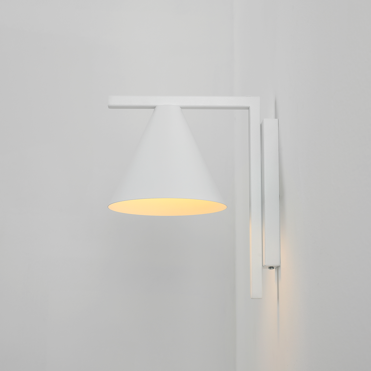 Kinkiet Form White w kolorze białym z kloszem w kształcie stożka. Montowany na ścianie, z widocznym źródłem światła E27. Prosty, nowoczesny design, umieszczony na jednolitym tle.