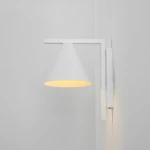 Kinkiet Form White w kolorze białym z kloszem w kształcie stożka. Montowany na ścianie, z widocznym źródłem światła E27. Prosty, nowoczesny design, umieszczony na jednolitym tle.