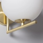 Kinkiet Riccardo Milano 1xE14 w kolorze złotym. Lampa z okrągłym, białym kloszem, montowana na ścianie. Widoczna metalowa konstrukcja oraz prosty, poziomy uchwyt. Zastosowanie: oświetlenie wnętrz.