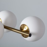 Lampa wisząca Conte Milano z sześcioma oprawami E27, zbudowana z metalowej złotej konstrukcji oraz matowych, białych kul. Widoczny detal mocowania na ścianie i elegancka, minimalistyczna forma. Ujęcie z góry, ukazujące kształt i połączenia elementów.