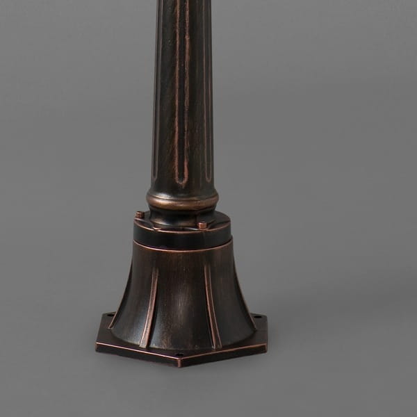 Lampa stojąca ogrodowa Amur 1-punktowa w ciemno-brązowym kolorze z dekoracyjnym, sześciokątnym podstawką i gładką, cylindryczną nogą. Widok z boku, ukazujący detale wykończenia i konstrukcję.