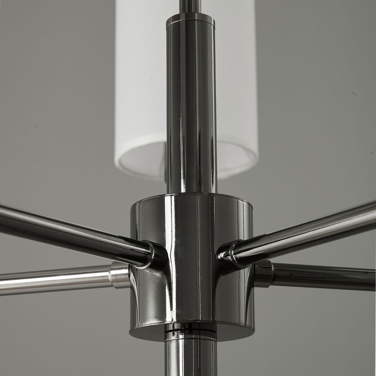 Lampa wisząca Darling w kolorze czarnym, z pięcioma oprawami E14. Metalowa konstrukcja z połyskiem, widoczny detal z centralnym elementem mocującym i białymi kloszami. Ujęcie z góry, ukazujące połączenie ramion.