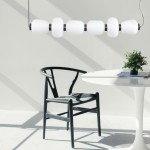 Lampa wisząca LED Brilla o mocy 69W i temperaturze barwowej 3000K, w kolorze czarnym, z sześcioma białymi kloszami w kształcie cylindrów, zawieszona nad białym stołem w minimalistycznym wnętrzu z czarnym krzesłem.