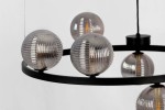 Lampa wisząca Monza z sześcioma oprawami G9, czarna z grafitowym wykończeniem. Okrągła konstrukcja z metalowym pierścieniem, na którym zawieszone są przezroczyste, żłobkowane klosze. Ujęcie z góry, eksponujące detale kloszy i ich rozmieszczenie.