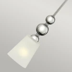 Lampa wisząca Zelda z kloszem w kształcie stożka, wykonana z matowego szkła, zawieszona na polerowanym niklowym stelażu z dekoracyjnymi kulami. Kąt ujęcia z góry, detal ujawnia elegancki design.