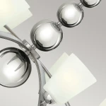 Lampa wisząca Zelda z polerowanego niklu, z ośmioma oprawami E27. Wyposażona w szklane klosze w kształcie prostokątów i okrągłe detale, prezentuje nowoczesny design. Ujęcie z góry, ukazujące szczegóły konstrukcji i materiałów.