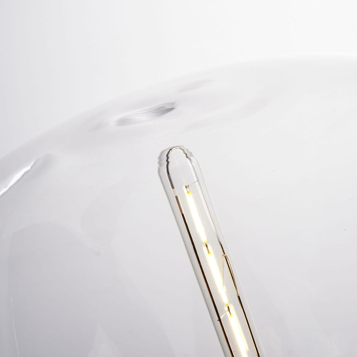 Lampa stołowa Block ST-7278-S GOLD z oprawą w kolorze złotym, z przezroczystym kloszem. Widoczna żarówka E27 z delikatnym światłem. Ujęcie z góry, podkreślające kształt klosza oraz detal żarówki wewnątrz.