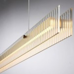 Lampa wisząca LED Longin, 15W, 3000K, złota, o prostokątnym kształcie z przezroczystymi, żłobionymi detalami. Zawieszona pod kątem, tworzy eleganckie oświetlenie. Wisi na cienkim, białym przewodzie na szarym tle.
