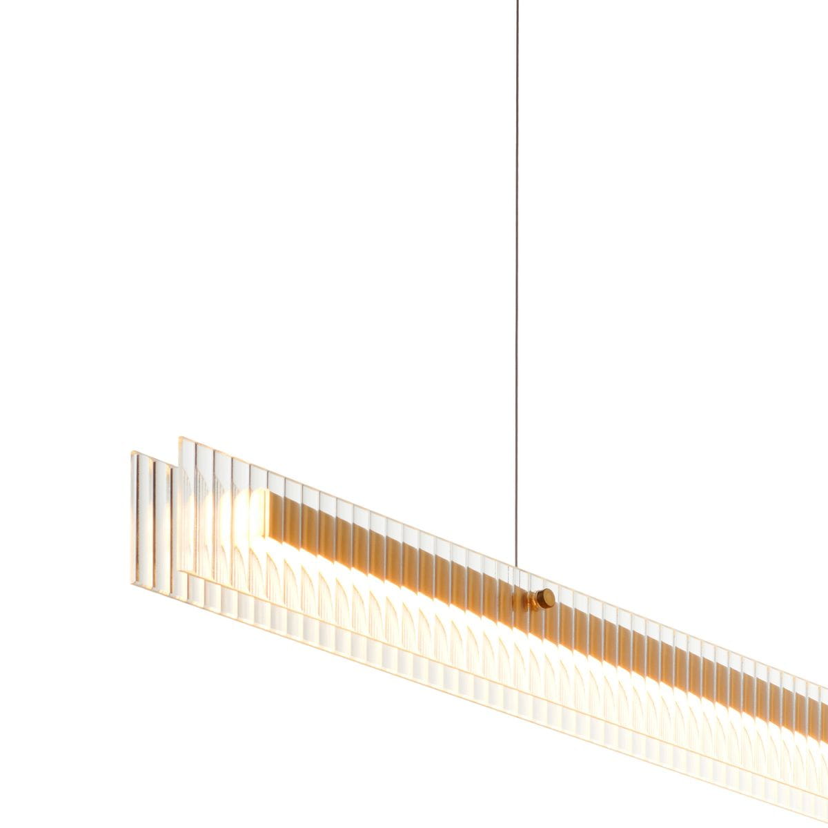 Lampa wisząca LED Longin o mocy 15W, barwie 3000K, w złotym kolorze. Posiada prostokątny kształt z przezroczystymi detalami i wyraźnymi liniami. Zawieszona na cienkim przewodzie, idealna do nowoczesnych wnętrz.