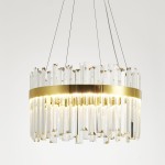 Złota lampa wisząca LED o mocy 52W i temperaturze barwowej 3000K, z kryształowymi elementami w formie prostokątnych pryzmatów. Ujęcie z boku, wisząca konstrukcja z metalowym pierścieniem, efektownie odbijająca światło. Tło proste, białe.