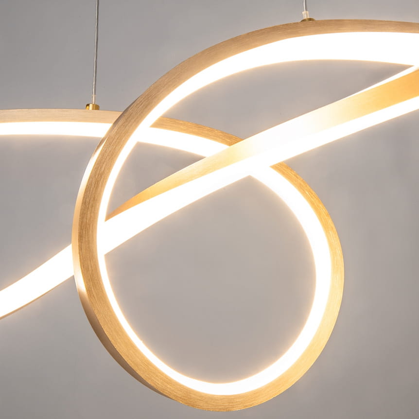 Złota lampa wisząca Curve LED o nowoczesnym, minimalistycznym kształcie składająca się z dwóch akrylowych pierścieni, emitujących ciepłe światło. Ujęcie z przodu, z widocznym zawieszeniem i oświetleniem wkomponowanym w obręcze.