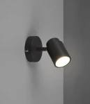 Kinkiet Angelo IP44 w kolorze czarnym, z okrągłą podstawą i regulowanym kloszem, montowany na ścianie. Lampa z jednym gniazdem GU10, emitująca jasne światło. Ujęcie z boku, na gładkiej, jasnej ścianie.