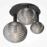 Lampa sufitowa Reels MOD268CL-03B z trzema kloszami E14 w kolorze czarnym. Klosze mają okrągły kształt z dekoracyjnymi, żłobionymi wzorami, wykonane z przezroczystego szkła. Całość zamontowana na prostokątnej podstawie.